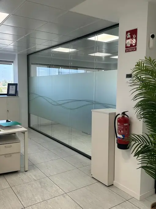 Mampara de vidrio para oficina, con lámina de vinilo Mamparas de cristal en Madrid, con perfil perimetral de aluminio negro.